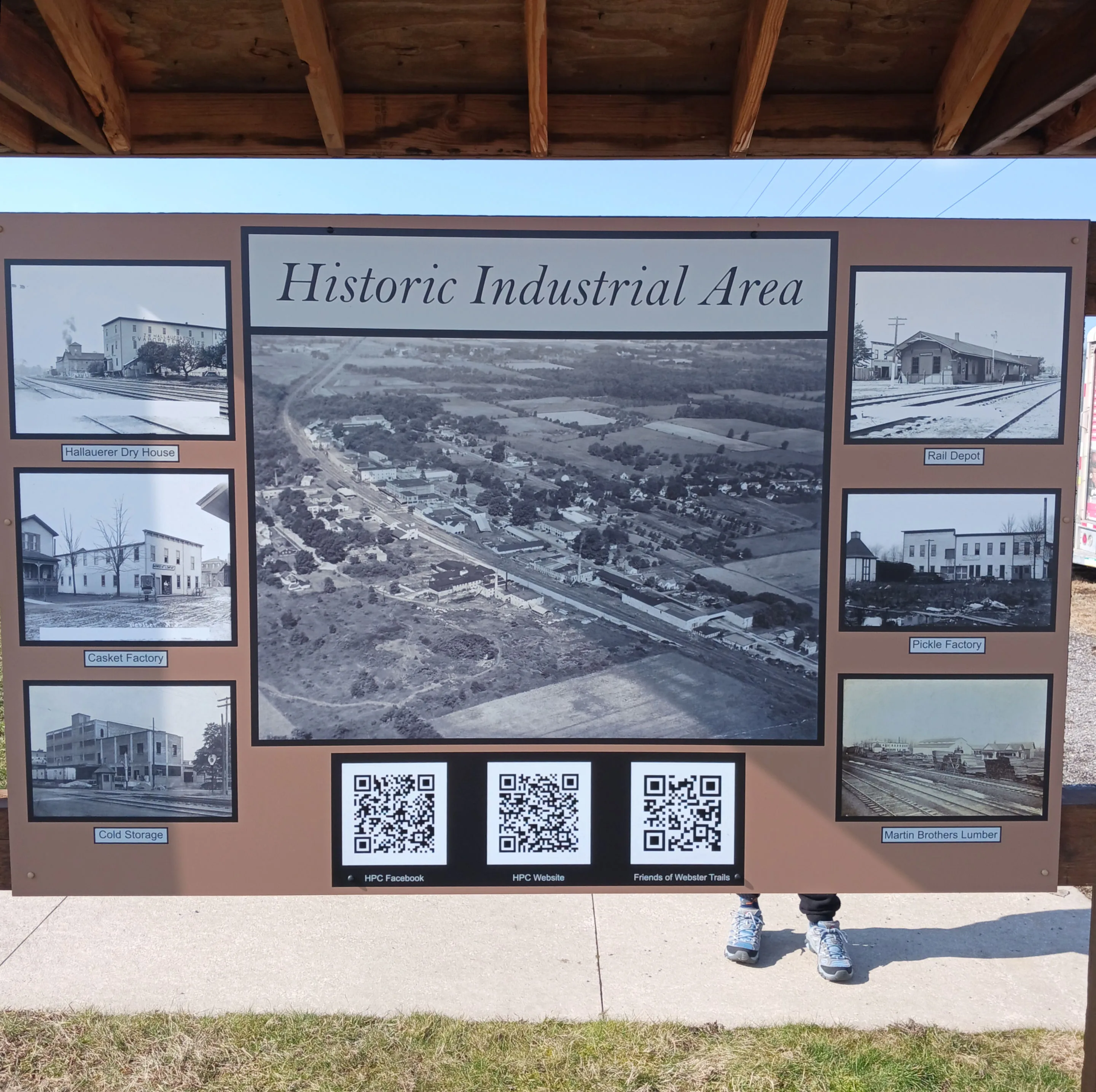A sign displaying historical pictures of the industrial area near the Hojack Trail in the Village of Webster.